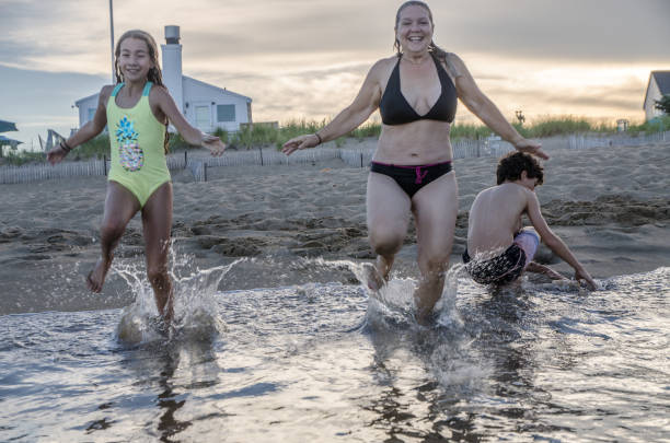 istock Mother and daughter running into the Atlantic Ocean 1420226731