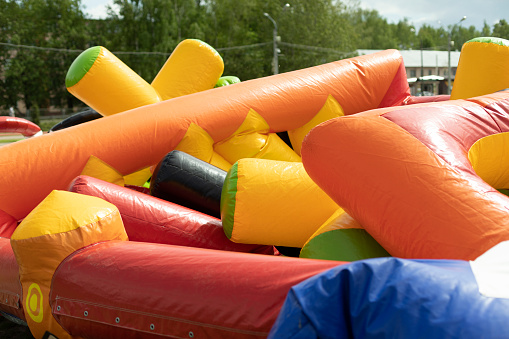 Deflate obstacle course in amusement park. Air escapes from inflatable structure. Details of collection of attractions. Preparation of holiday.