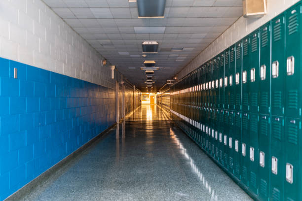 istock Green metal lockers along a nondescript hallway in a typical US High School.  No identifiable information included and nobody in the hall. 1420229114