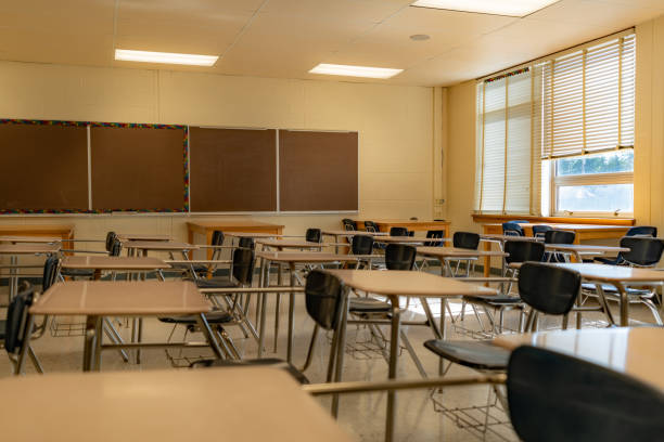 istock Example of an empty nondescript US High School Classroom with desks, Window and black board. 1420229140
