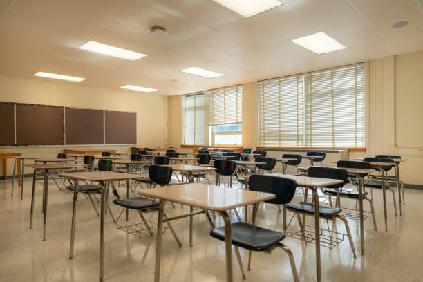 istock Example of an empty nondescript US High School Classroom with desks, Window and black board. 1420229168