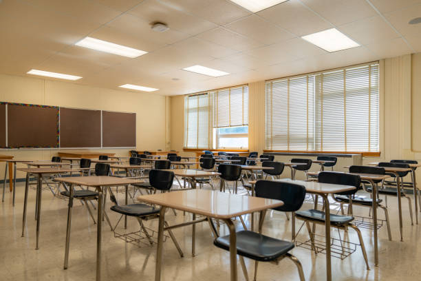 istock Example of an empty nondescript US High School Classroom with desks, Window and black board. 1420229171