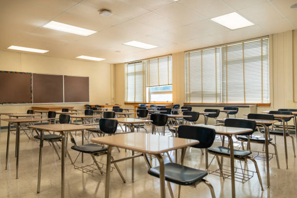 istock Example of an empty nondescript US High School Classroom with desks, Window and black board. 1420229195
