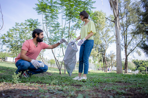 people picking up garbage in a park