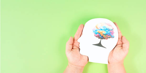 istock Holding a head with a colorful tree in the hands, symbol for creativity, connection to nature and positive emotion, living in a dream world 1420238855