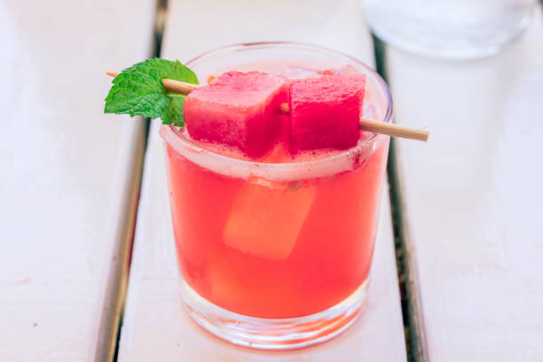 Watermelon Margarita A Watermelon Margarita sits on a wood slat table, freshly prepared watermelon juice stock pictures, royalty-free photos & images