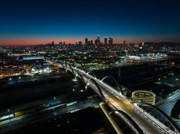 Sixth Street Bridge and Downtown LA at Night - Aerial Aerial view of the new Sixth Street Viaduct connecting  the Downtown Los Angeles Arts District to Boyle Heights across the Los Angeles River at nightfall. sixth street bridge stock pictures, royalty-free photos & images