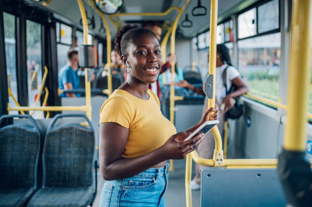 istock African american woman standing in a moving bus and using a smartphone 1420249276