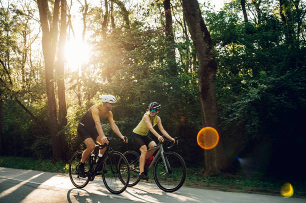 istock Couple riding road bicycles outside and wearing helmets and sunglasses 1420249295