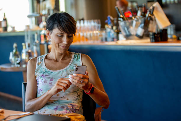 istock Woman using a smart phone in bar 1420258796