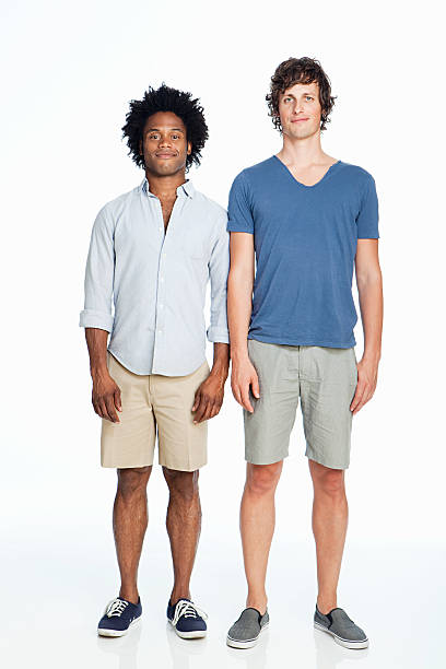 Gay couple standing against white background  shorts stock pictures, royalty-free photos & images