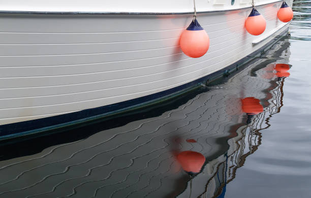 istock Three bright orange buoys hanging on side of boat 1420269121