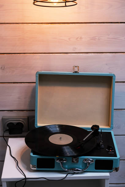 istock Analog vinyl record player with disc on white table. Modern turntable audio equipment. 1420282847