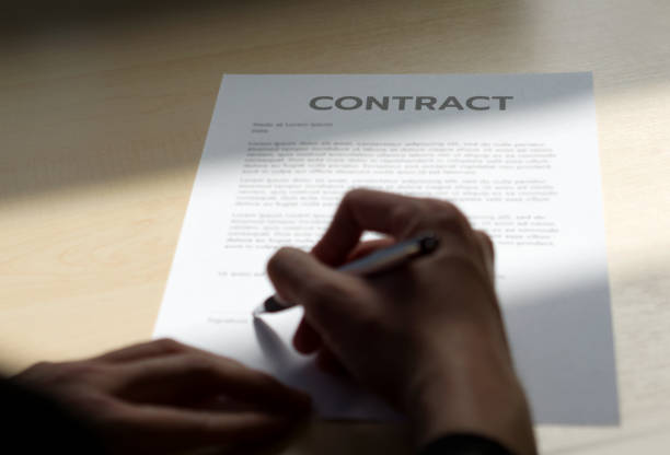 istock Contract document on wooden table with sunlight shines on it. 1420295135