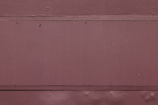 Section of an old maroon wooden wall.