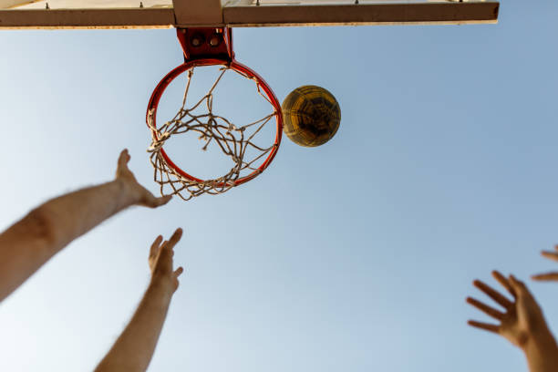 istock Hands throwing a basket ball in the hoop while playing on outdoors court 1420302248