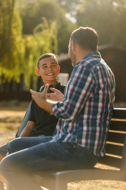 istock Cheerful father gesturing while sharing a funny story with his teenage son 1420303207