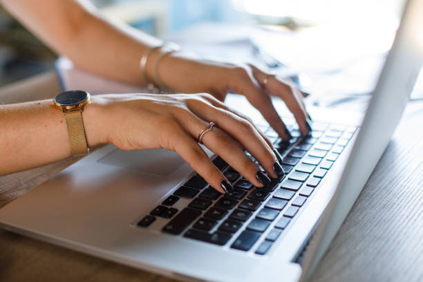 istock Young woman typing an email on laptop keyboard when working at her desk 1420307281
