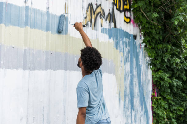 Two young street artist best friends draw colorful graffiti with sprays