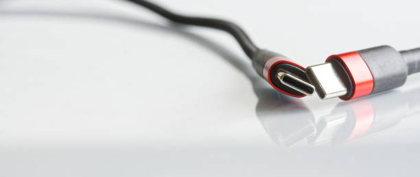 istock Two red-black usb type-c connectors with wires on a light background. Minimalism. A modern way to connect, transfer data and charge gadgets. Macro. Selective focus. Copy space 1420308571