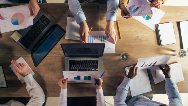 istock Diverse business people reviewing various documents during a project meeting 1420310950