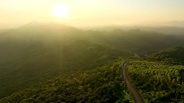 Driving on the hill at sunrise, hopeful, warm, shot by 4k ProRes Drone