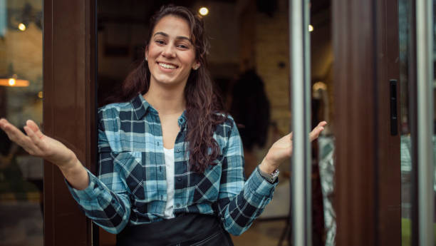 istock A young waitress in a plaid shirt greets her customers. 1420315494