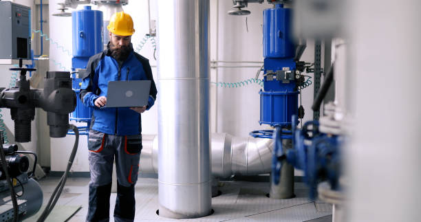 istock Energy plant interior. 
The worker uses a laptop. 1420315515