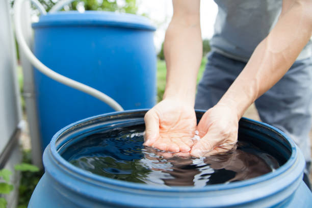 man collecting rainwater in barrel