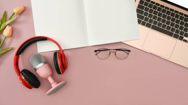 istock Top view wireless headphone, microphone for podcasts, notepad and laptop on pink background. 1420321949
