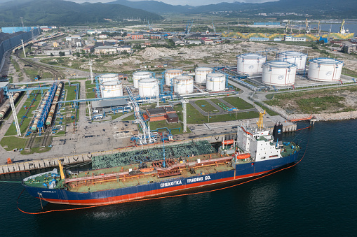 Nakhodka, Russia - July 31, 2022: The top view on Oil-storage tank with the tanker at a mooring.