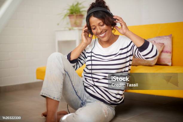 Music Relax And Retirement With A Senior Or Elderly Woman Listening With Headphones On The Floor At Home Carefree Time To Listen To The Radio Or Audio While Resting And Relaxing In The Living Room Stock Photo - Download Image Now