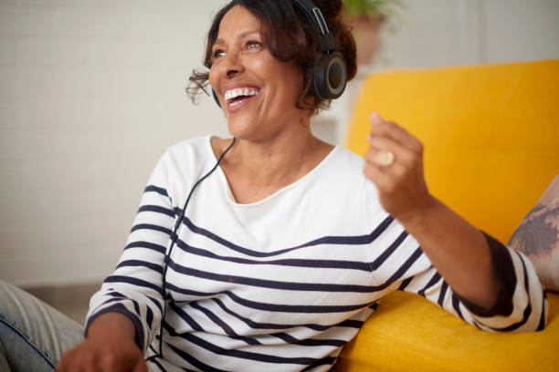 Relax senior woman listening to a podcast, radio or streaming music online while sitting on the floor at home. Mature African American female smiling and enjoying an audiobook in her house Team, budget and financial report with graphs, paperwork and SEO information for marketing and economy research. Man and women planning accounting finance strategy and stock market data analytics old person listening to radio stock pictures, royalty-free photos & images