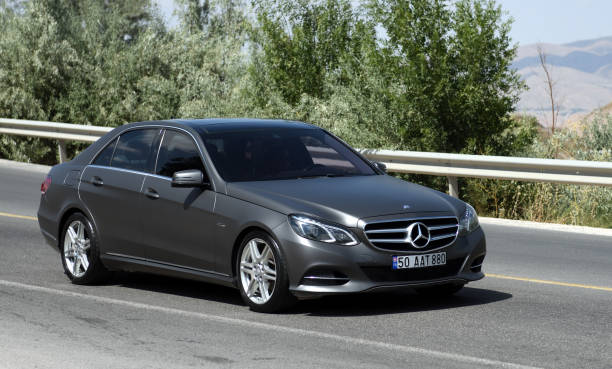 mercedes c-class w205 car moves along the highway in the mountains. - capital letter luxury blue image imagens e fotografias de stock