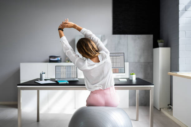 istock Employee Exercising On Ball In Office 1420323165