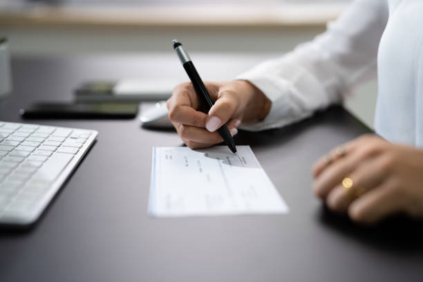 istock Woman Signing Bank Check 1420323292