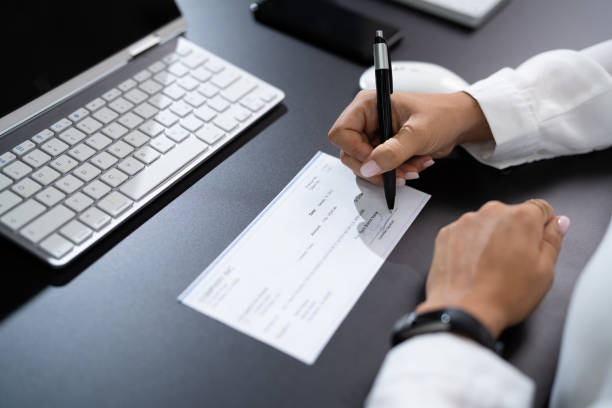 istock Woman Signing Bank Check 1420323298