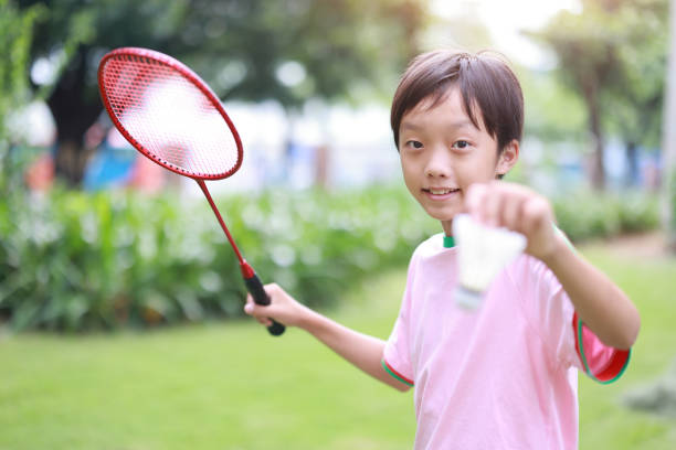 istock Boy playing badminton in public park 1420327046
