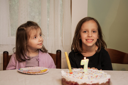 Two sisters sitting at home during birthday party