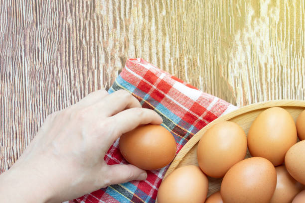 istock Woman's hand pick up egg bowl  for preparing food. 1420332814