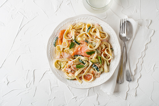 Seafood tagliatelle pasta with smoked salmon in cream sauce. Healthy vegetarian meal