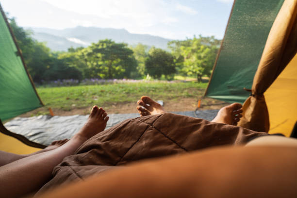 istock Two people lying in tent with a view of forest and mountains. 1420337151