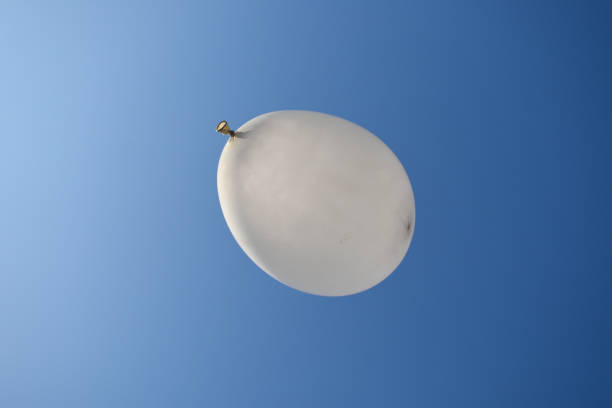 Blank white balloons with copy space area flying in the blue sky among the clouds
