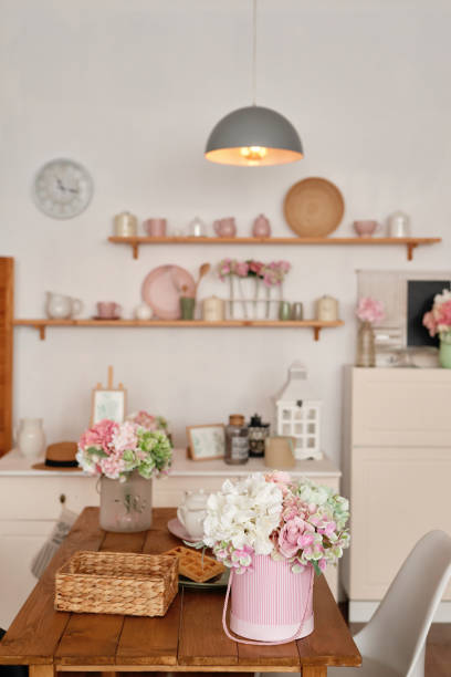 istock White kitchen interior in loft style. Shelves with pink crockery and kitchen utensils. Studio apartment. Rent and delivery of housing. Hostel and hotel 1420347603
