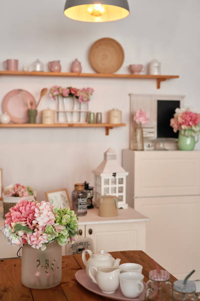 istock White kitchen interior in loft style. Shelves with pink crockery and kitchen utensils. Studio apartment. Rent and delivery of housing. Hostel and hotel 1420347723