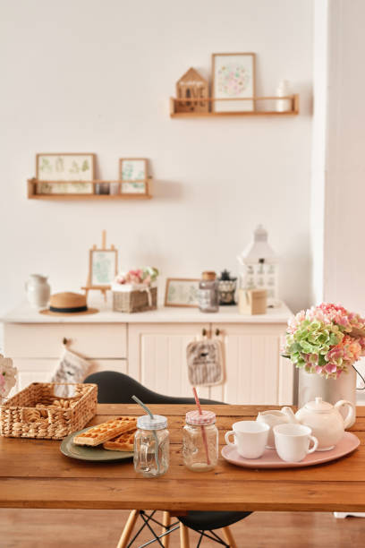 istock White kitchen interior in loft style. Shelves with pink crockery and kitchen utensils. Studio apartment. Rent and delivery of housing. Hostel and hotel 1420347725