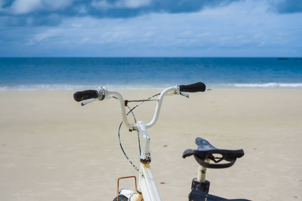 An attractive young woman riding her bicycle on the beach
