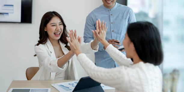 istock High-five! cheerful young business people giving high-five while their colleagues looking at them and smiling 1420355768