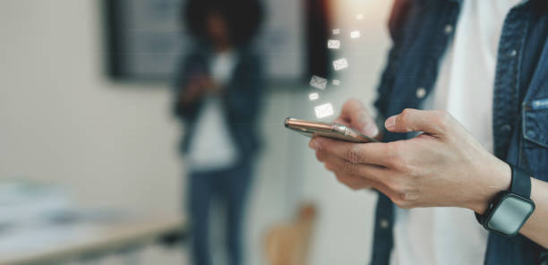 istock Close-up image of young man hands using smartphone with icon envelope email. Contact us customer service or e-mail marketing concept 1420357378