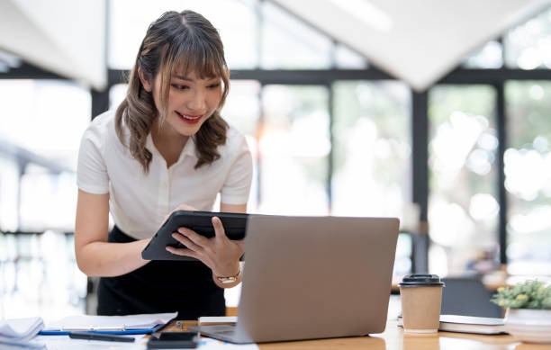 istock Happy businesswoman using digital tablet analyzing weekly schedule at her office desk. 1420357692